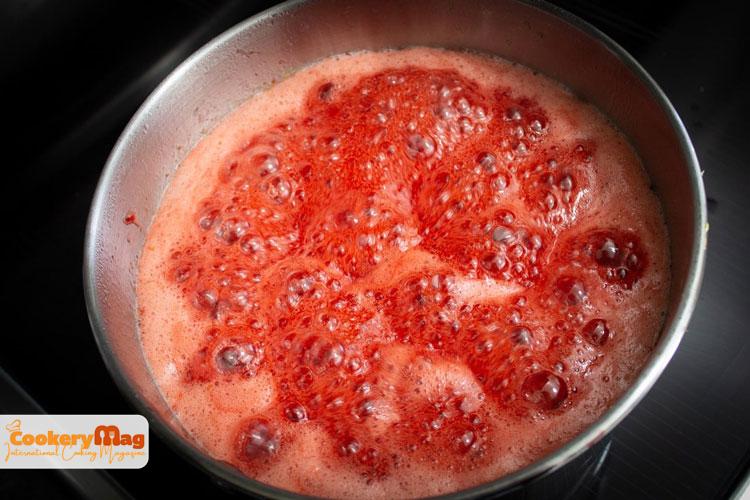 pink foam on strawberry jam pot